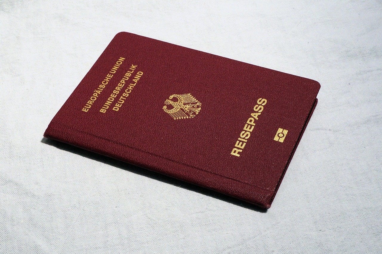 Deutscher Reisepass mit bordeauxrotem Einband und goldenem Bundesadler auf hellem Stoff